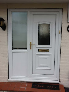 White aluminium front door with glass panel installed on a modern Ghana home