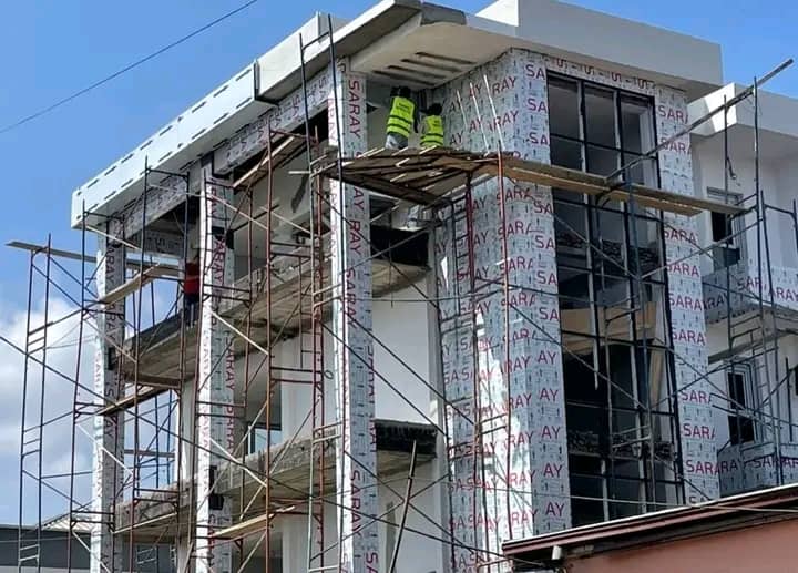 Skilled Alucobond Ghana workers installing aluminium composite cladding on a commercial building