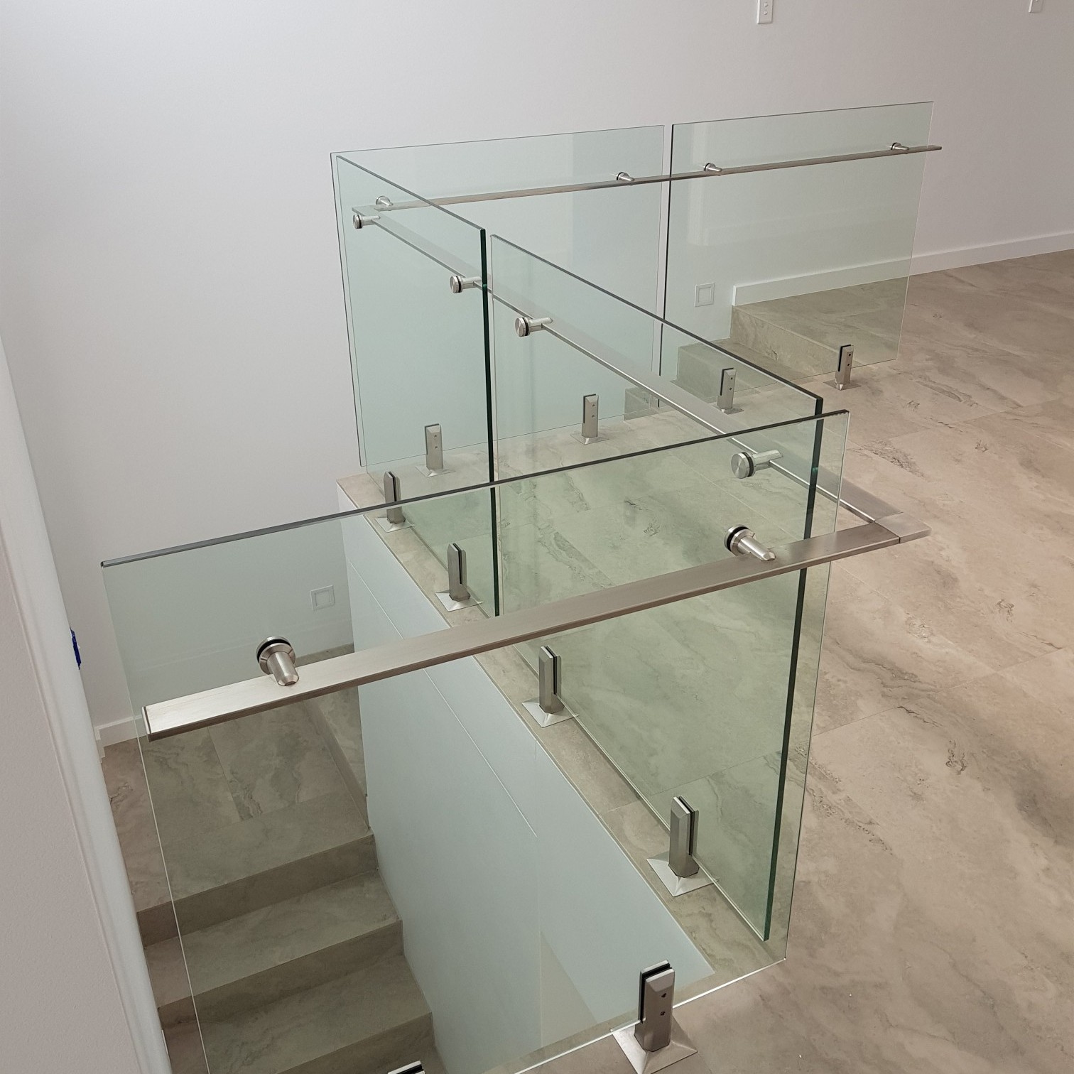 Contemporary glass staircase railing installed by Alucobond Ghana in a modern building